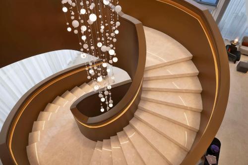 a spiral staircase in a building with a chandelier at Embassy Suites By Hilton Dubai Business Bay in Dubai