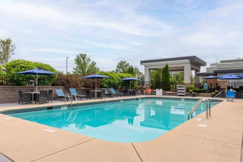 a swimming pool with tables and chairs and umbrellas at Hampton Inn Manchester Downtown in Manchester
