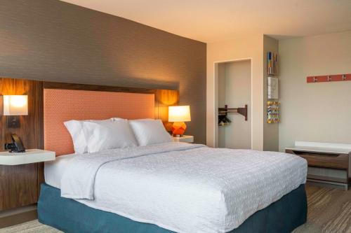 a hotel room with a large bed with white sheets at Hampton Inn Manchester Downtown in Manchester