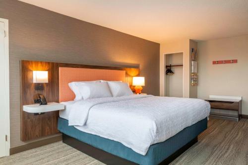a large bed in a hotel room with two lamps at Hampton Inn Manchester Downtown in Manchester