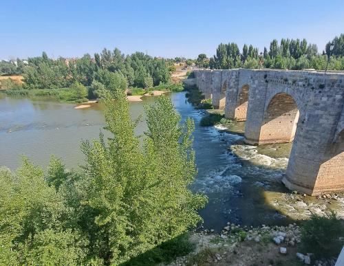 an old stone bridge over a river at El Rincón del Pisuerga con Terraza in Cabezón de Pisuerga