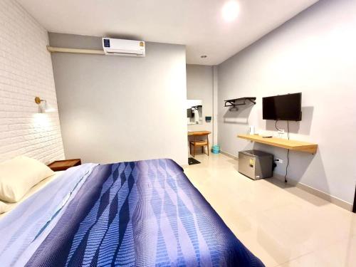 a bedroom with a bed and a desk and a tv at Klong Cafe & Resort in Pathum Thani