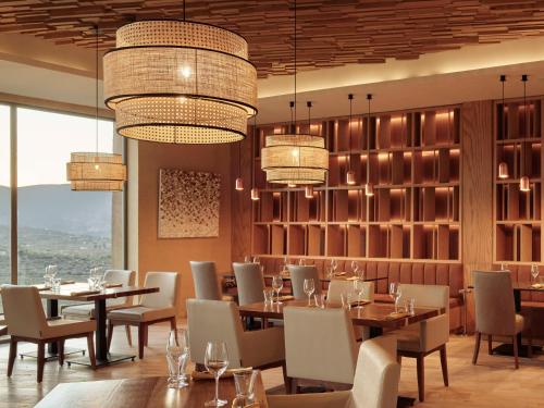 a dining room with tables and chairs and chandeliers at Banyan Tree Veya, Valle de Guadalupe - A Wellbeing & Wine Resort in Valle de Guadalupe
