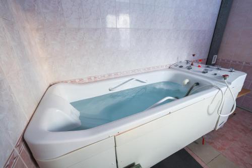 a bath tub with blue water in a bathroom at Aquadar in Manʼkivka