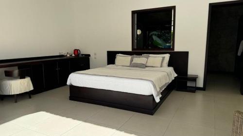 Un dormitorio con una cama grande y un escritorio. en Residence Bel été, en Trou aux Biches