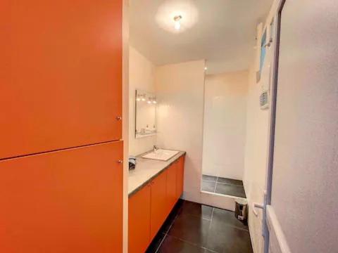 La salle de bains orange est pourvue d'un lavabo et d'un miroir. dans l'établissement Centre ville - cosy appartement - sous les parapluies, à Grasse