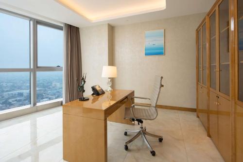 a room with a desk with a phone and a chair at Hilton Brazzaville Les Tours Jumelles Hotel & Residences in Brazzaville