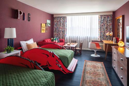 a hotel room with two beds and a desk at Graduate by Hilton Fayetteville, AR in Fayetteville