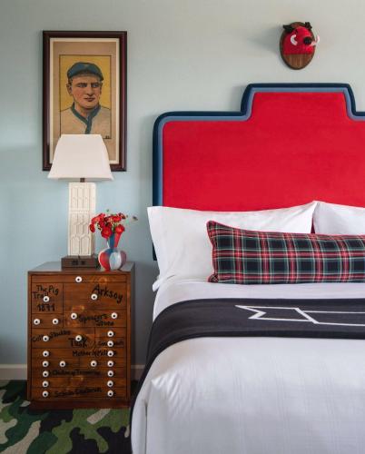 a bedroom with a bed with a red headboard at Graduate by Hilton Fayetteville, AR in Fayetteville