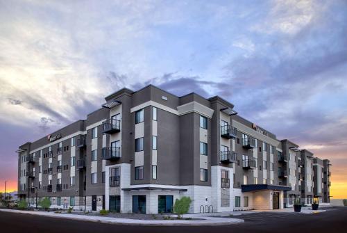 a large apartment building in front of a sunset at WaterWalk Extended Stay by Wyndham Tucson in Tucson