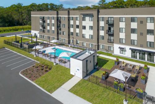 an aerial view of a hotel with a pool and a building at WaterWalk Extended Stay by Wyndham Jacksonville Deerwood Pk in Jacksonville
