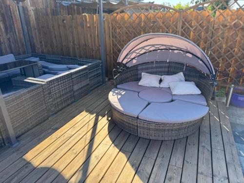 a wicker bed sitting on a wooden deck at Sielski Zaułek Guciów u Dorotki -Basen,Jacuzzi,Sauna in Guciów