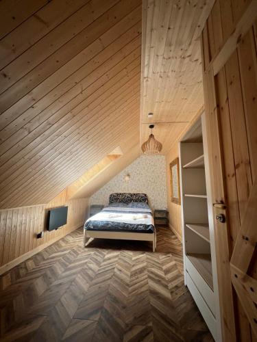 a bedroom with a bed and a wooden ceiling at Sielski Zaułek Guciów u Dorotki -Basen,Jacuzzi,Sauna in Guciów