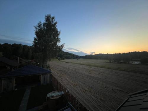 a view of a field with a fence and the sunset at Sielski Zaułek Guciów u Dorotki -Basen,Jacuzzi,Sauna in Guciów