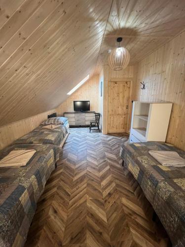 two beds in a room with wooden walls at Sielski Zaułek Guciów u Dorotki -Basen,Jacuzzi,Sauna in Guciów