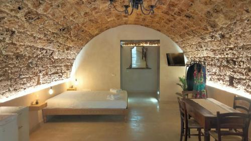 ノートにあるLA GROTTA, luxury suite & Spaのベッドとテーブルと椅子のある寝室