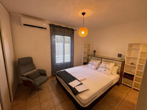 a bedroom with a bed and a chair at Appartement entier Saint Pierre Centre dans résidence de prestige in Saint-Pierre