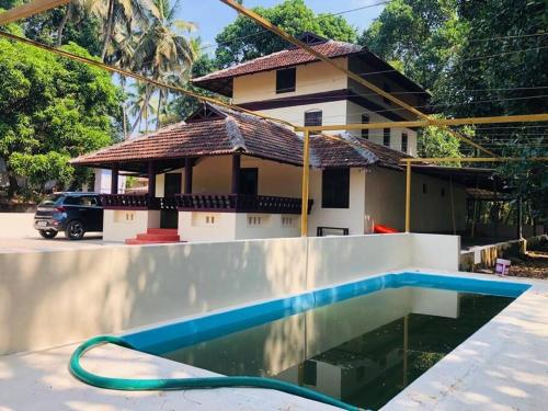 a house with a swimming pool in front of a house at Neermathalam, a traditional kerala tharavadu in Palakkad