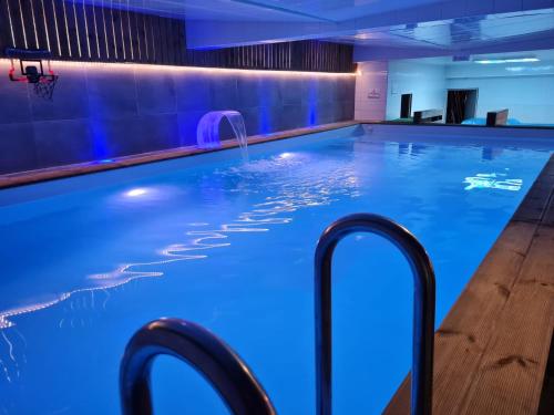 - une piscine avec éclairage bleu dans l'établissement Gîte Amazonia, à Dijon