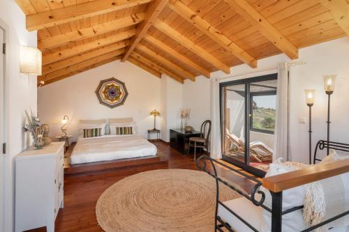 Schlafzimmer mit einem Kingsize-Bett und Holzdecken in der Unterkunft Casa da Raposeira by An Island Apart in Calheta