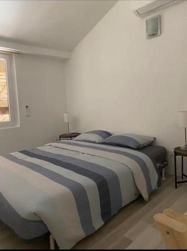 une chambre avec un lit avec deux oreillers dessus dans l'établissement Appartement 60m2 - 2 ou 4 pers, à Biziat