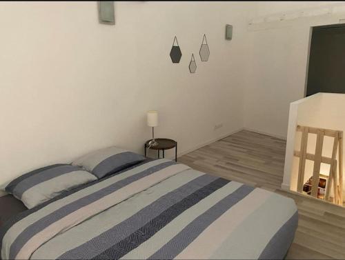 une chambre avec un lit à rayures bleues et blanches dans l'établissement Appartement 60m2 - 2 ou 4 pers, à Biziat