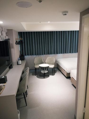 a hotel room with a bed and a table and chairs at 新仕飯店-New City Hotel in Taipei