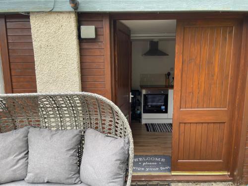 a wicker chair with two pillows sitting in front of a door at Yairbrig Holiday in Galashiels