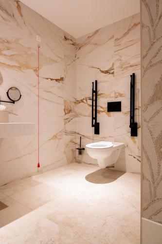 a white bathroom with a sink and a toilet at Van der Valk Hotel Eindhoven-Best in Best