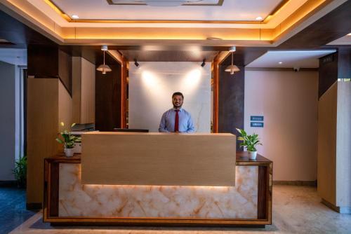 a man standing behind a counter in a lobby at Evara Hills, Gangtok in Gangtok
