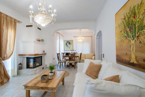 a living room with a white couch and a table at Georgia apartments and suites in town in Skiathos
