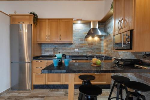 a kitchen with wooden cabinets and a black counter top at Los Almendr2s in Frontera