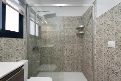 a bathroom with a shower with a toilet and a sink at Los Almendr2s in Frontera