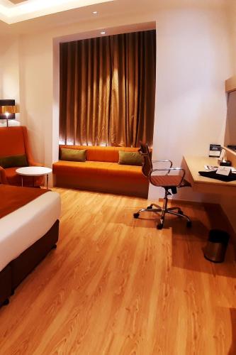a hotel room with a bed and a desk and a couch at Best Western Vrindavan in Vrindāvan