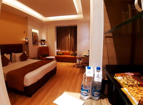 a hotel room with a bed and a table with bottles of water at Best Western Vrindavan in Vrindāvan
