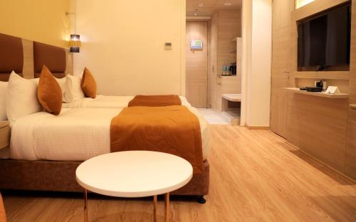 a hotel room with a bed and a table at Best Western Vrindavan in Vrindāvan