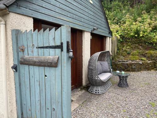 a wicker chair sitting outside of a building at Yairbrig Holiday in Galashiels