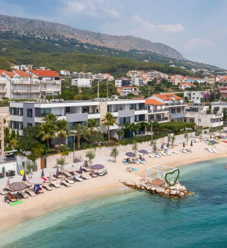 an aerial view of a beach with chairs and umbrellas at Paoma Luxury Beach Suite with jacuzzi in Podstrana