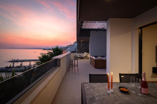 a balcony with a view of the ocean at sunset at Paoma Luxury Beach Suite with jacuzzi in Podstrana