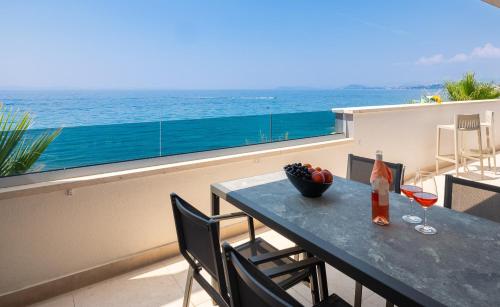a table on a balcony with a view of the ocean at Paoma Luxury Beach Suite with jacuzzi in Podstrana