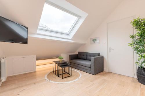 un salon avec un canapé et une fenêtre dans l'établissement Lille centre - Bel appartement sous les combles !, à Lille