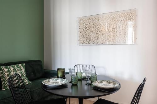 - une table à manger avec un canapé vert dans l'établissement Appartement Aulne - Welkeys, à Paris
