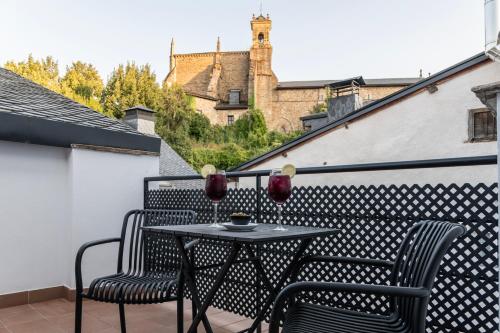 a patio with two chairs and a table on a balcony at Hotel & Restaurante El Casino in Villafranca del Bierzo