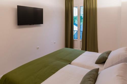a bedroom with a bed with a television on the wall at Hotel & Restaurante El Casino in Villafranca del Bierzo