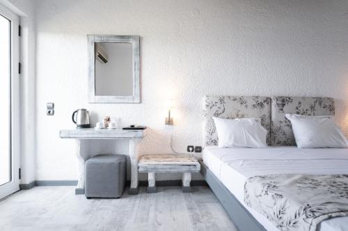 a white bedroom with a bed and a sink at Long Beach Hotel & Resort in Lóngos