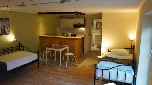 une petite chambre avec deux lits et une petite cuisine dans l'établissement Landhof Luna, à Gevelsberg