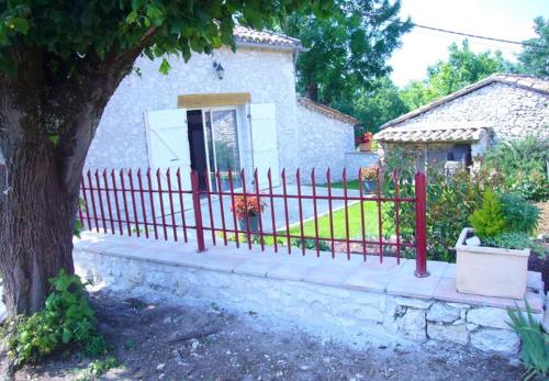 a red fence in front of a house at Maison des pruniers in Massels