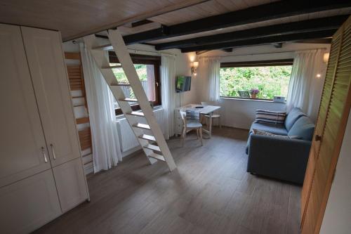 a living room with a loft bed and a table at Blockhaus Quellental in Odderade