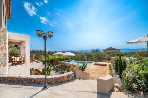 a villa with a swimming pool and a street light at Petradi Suites in Kalamata
