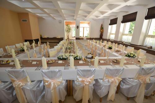 a large room with a long table with white tables and chairs at Chata Patúch in Babkov